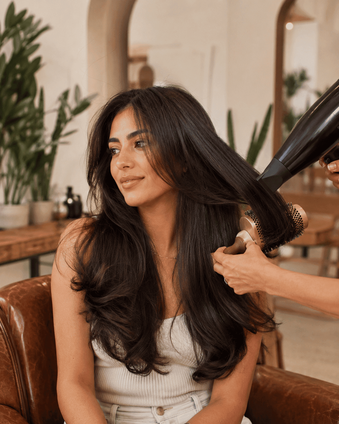 Woman with long hair getting a blow-dry at a salon.